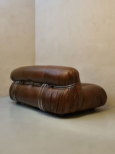 a brown leather chair sitting on top of a white floor