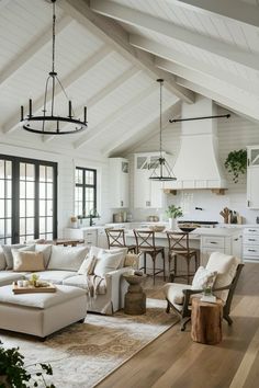 a living room filled with furniture and lots of windows in the ceiling above it is an open kitchen