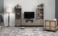 a living room with a large rug and entertainment center