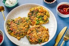 three frittatas on a white plate with sauces and condiments