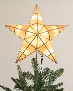 a lighted star on top of a christmas tree