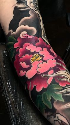 a woman's arm with flowers and a bird on the back of her leg