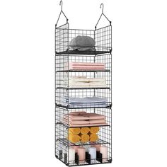 an iron wire shelf with towels and other items on the bottom rack, in front of a white background