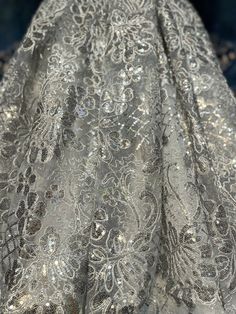 Good quality, sparkly, and unique embroidered silver grey floral lace with sequins. Width is 48”-50”. Sold by the yard. Elegant Silver Sequin Fabric With Floral Embroidery, Silver Embellished Lace For Party, Embroidered Silver Lace For Wedding, Fitted Silver Lace For Party, Silver Embroidered Lace For Party, Silver Embroidered Lace For Wedding, Silver Embroidered Wedding Lace, Fitted Silver Embroidered Fabric For Festive Occasions, Silver Embellished Embroidered Fabric For Reception