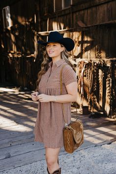 Introducing The Zuri Dress, a playful knee-length western dress in a gorgeous rust color. Made from textured fabric, this dress features a flattering fit and flare silhouette with short sleeves and a v neckline. Complete with a collared button down design and pocket detail, it's the perfect dress for fall fun! Haylee is wearing size small paired with the Ariat Casanova Boots, Felt Cowboy ProHat and The Talia Bag Brown Short Sleeve Mini Dress For Fall, Brown Mini Dress With Short Sleeves For Fall, Brown Short Sleeve Dress With Pockets, Brown Short Sleeve Shirt Dress For Fall, Brown Short Sleeve Shirt Dress For Work, Zuri Dress, Dress For Fall, Western Dress, Wild Rag