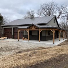 a two car garage with an attached carport and covered in wood shinnings