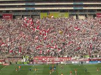 a large stadium filled with lots of people watching soccer game on the field in front of an audience