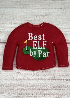 a red sweater with the words best elf by par on it and a green golf ball