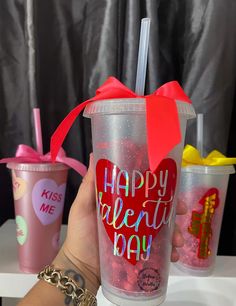 a person holding up a plastic cup that says happy valentine's day