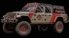 a red and gray jeep with four wheels parked in front of a black background,