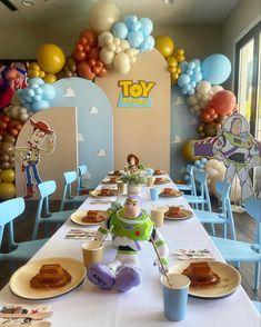 a toy story themed birthday party with balloon decorations and desserts on the table,