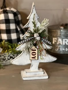 a small white christmas tree sitting on top of a table next to other holiday decorations