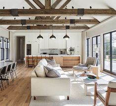 a living room filled with furniture and lots of windows next to a dining room table