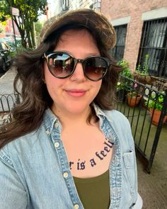 a woman wearing sunglasses and a denim shirt with words on her chest that says, your is a friend