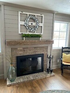 a living room filled with furniture and a fire place covered in a wreath on top of a mantle