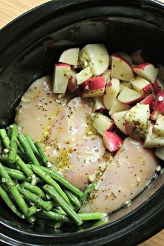 chicken, potatoes and asparagus in a pan with seasoning on top for garnish