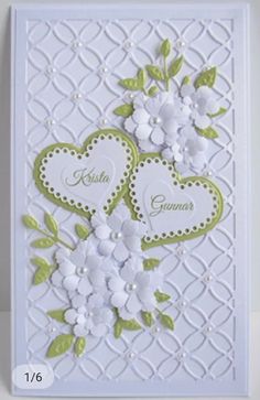 a card with two hearts and flowers on the front, one is green and white