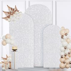 an arch decorated with balloons and flowers in front of a white backdrop for a party