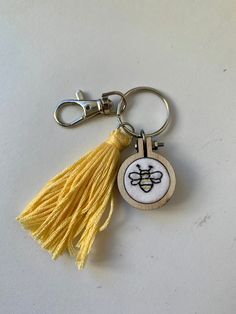 a yellow tasseled keychain with a bee on it