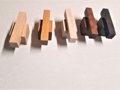 five pieces of wood are lined up on a white surface, with one piece missing