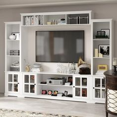 a white entertainment center with shelves and a flat screen tv mounted on it's wall