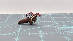 a toy dachshund dog with a name tag on it's collar