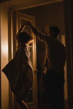 two people standing in front of a door with their hands on each other's head