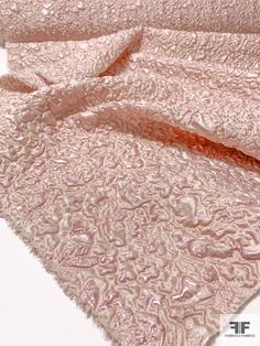 an image of a pink bed spread on top of a white tablecloth with water droplets