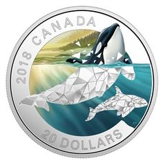 a silver coin with two orca whales swimming in the water