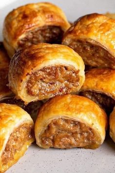 several sausage rolls stacked on top of each other in a white plate with red sauce