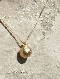 This is a 14 karat solid gold ball pendant necklace. It is a minimalist gold ball. solid gold pendantA 14 karat solid gold ball dangles on a 14 karat solid gold chain. It's a small, concentrated pendant with high density.This listing is for one 14 karat gold pendant on a 42 cm, 14 karat gold chain.ITEM  DETAILS:Handmade itemThe length of the necklace is 42 cm.Materials:14 k solid gold Ball diameter: approx. 7 mmPendant total length (including the bail): approx.8 mm.Ball pendant weight: app. 1.7g Gold Sphere Ball Chain Jewelry, Minimalist Jewelry With Round Pendant Ball Chain, Minimalist Jewelry With Ball Chain And Round Pendant, Minimalist Gold Sphere Necklaces, Gold Ball Pendant, Gold Ball Necklace, Wax Jewelry, Ball Pendant Necklace, Big Statement Earrings