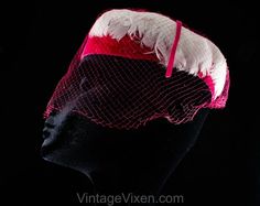 This dome-shaped 1960s spring hat is a soft layer of thick white feathers over a base of vivid pink velvet, so charming and coy with a "cage" of veiling.  Measurements  20 3/8 Inches Circumference at inside base of crown, approx Height 3 Inches   Era  1960s  Label  Union label to inside back  Materials  White feathers, shocking pink synthetic velvet and matching diamond pattern net, matching pink stiff buckram frame  Closure  None needed   Condition  Good  Condition Detail  Barely worn, the nett Retro Pink Brimmed Hat, Vintage Pink Fitted Fascinator, Vintage Pink Adjustable Mini Hats, Pink Vintage Costume Hat For Parties, Vintage Pink Costume Hats And Headpieces For Party, Pink Retro Party Hats, Vintage Pink Party Hat And Headpiece, Vintage Pink Mini Hat With Curved Brim, Fitted Vintage Pink Hat