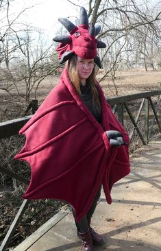 a woman wearing a red dragon cape and boots