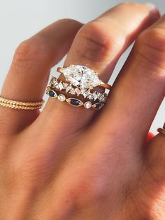 a woman's hand with three different rings on it