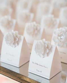 small white flowers are on display in a glass case at a wedding ceremony or reception