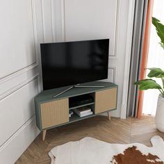 a flat screen tv sitting on top of a wooden stand in a living room next to a potted plant