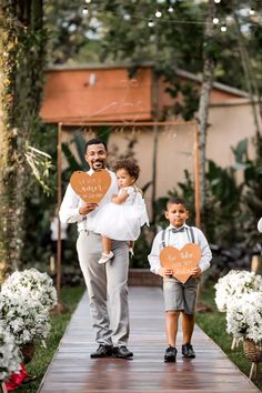 a man and two children walking down a wooden walkway holding signs that say happy father's day