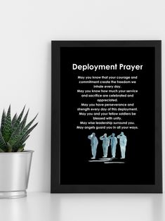 a framed poster with the words deployment prayer on it next to a potted plant