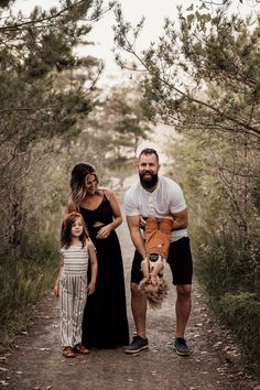 a man, woman and child standing on a path