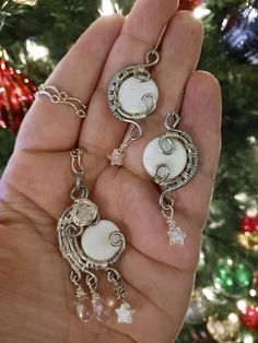 a person is holding three different necklaces in front of a christmas ornament