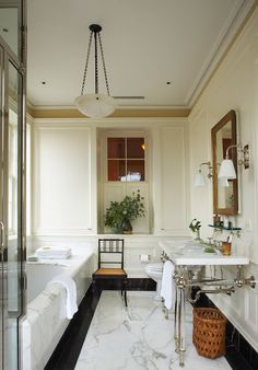 a bathroom with marble floors and white walls, along with a bathtub that has been decorated in black and white