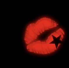 a black and red photo with a star on it's lip in the dark