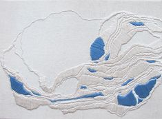 an embroidered piece of cloth with blue and white designs on it