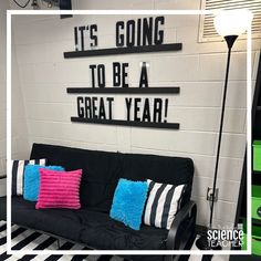 a black and white striped floor next to a green wall with some pillows on it