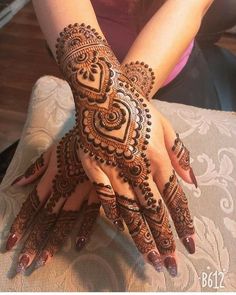 a woman's hands with hennap on it, showing the intricate design