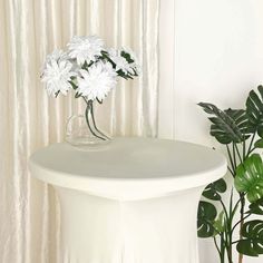 white flowers are in a vase on a table