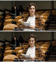 a man sitting in an auditorium reading a book