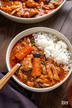 two bowls filled with meat and rice on top of a wooden table