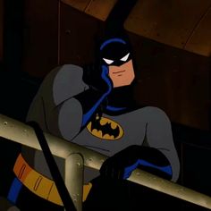 the batman animated character is sitting on a ledge