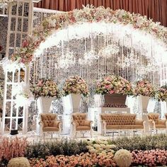 an elaborate wedding stage set up with flowers and chandelier